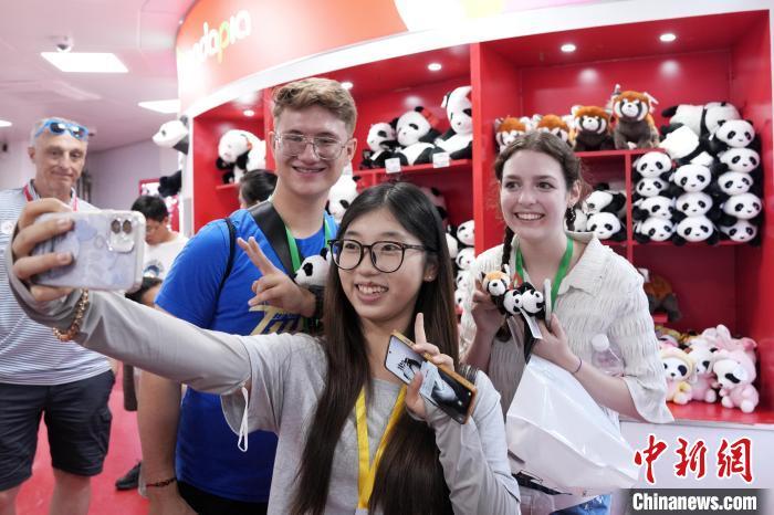 6月26日，参加中国石油大学(北京)夏令营的美国高校师生参观北京动物园。图为中美青年与熊猫文创自拍。张祥毅 摄