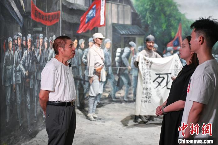 22日,两岸媒体采访团在建川博物馆聚落采访川军“死”字旗故事主人公王建堂之侄王烈勋(左)。记者 刘忠俊 摄