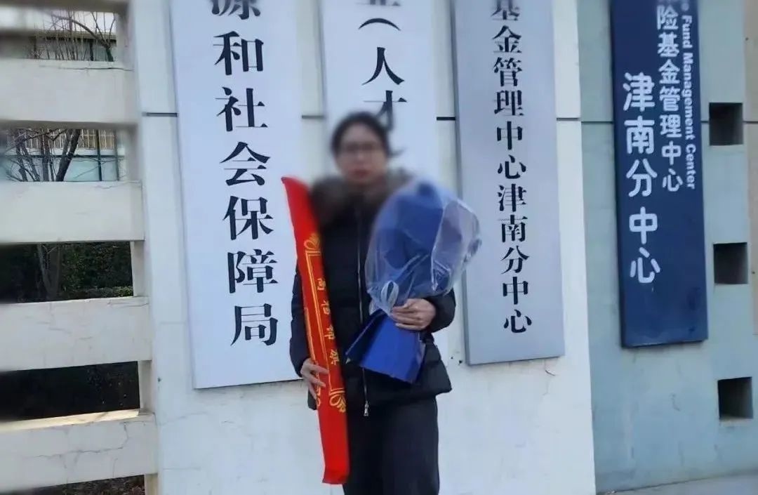工伤认定成功后的崔丽丽站在人社局大门前