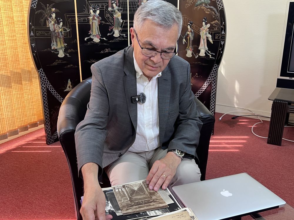 2025年6月23日，贝石涛在巴黎近郊接受记者采访时翻看与贝熙业医生相关的历史资料。新华社记者 孙鑫晶 摄