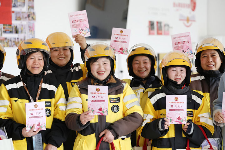 2025年3月7日，在山东省临沂市郯城县郯城街道龙泉社区，外卖女骑手展示妇联发放的妇女维权公益服务知识手册。新华社发（张春雷 摄）