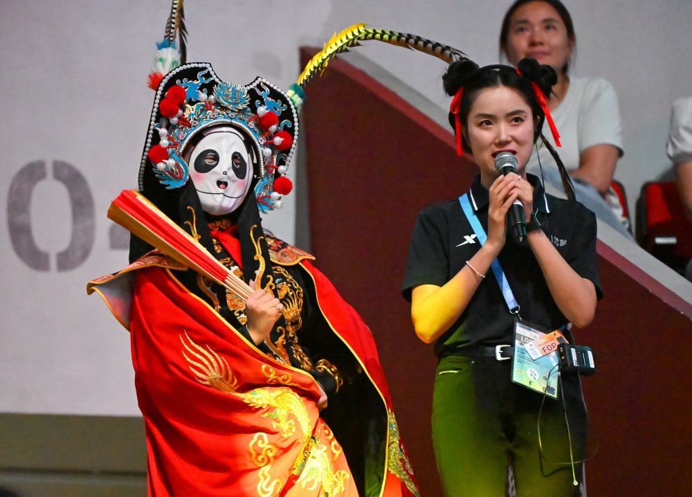 ↑8月10日,川剧变脸表演者在成都世运会技巧和蹦床比赛决赛前进行暖场表演。