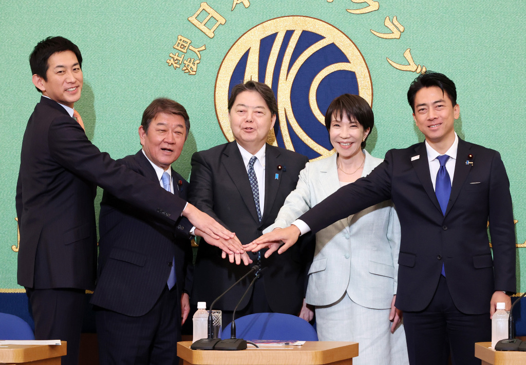 当地时间2025年9月24日，日本东京，日本执政党自由民主党总裁选举候选人（从左至右）前经济安全保障担当大臣小林鹰之、自民党前干事长茂木敏充、内阁官房长官林芳正、前经济安全保障担当大臣高市早苗和农林水产大臣小泉进次郎在辩论会上合影。视觉中国 图
