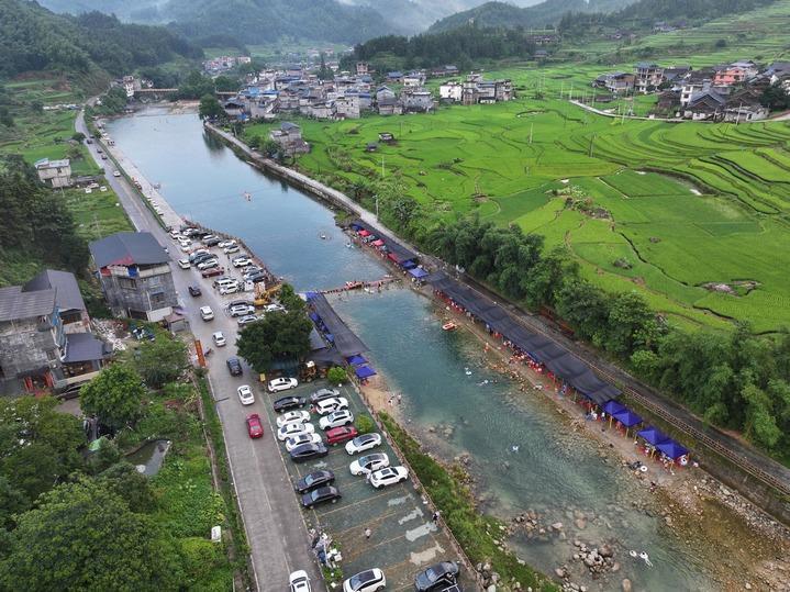 游客在广西柳州市融水苗族自治县香粉乡雨卜村戏水消暑(7月19日摄,无人机照片)。新华社记者 黄孝邦 摄