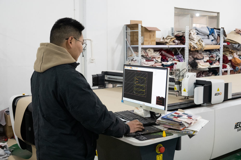 六安市忠缘婚纱礼服有限公司工厂负责人许小龙在操作电脑自动裁床。新华社记者 赵金正 摄