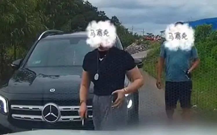 奔驰车上的男女下车和“平头哥”沟通让路,女司机左手中疑拿着一物品。