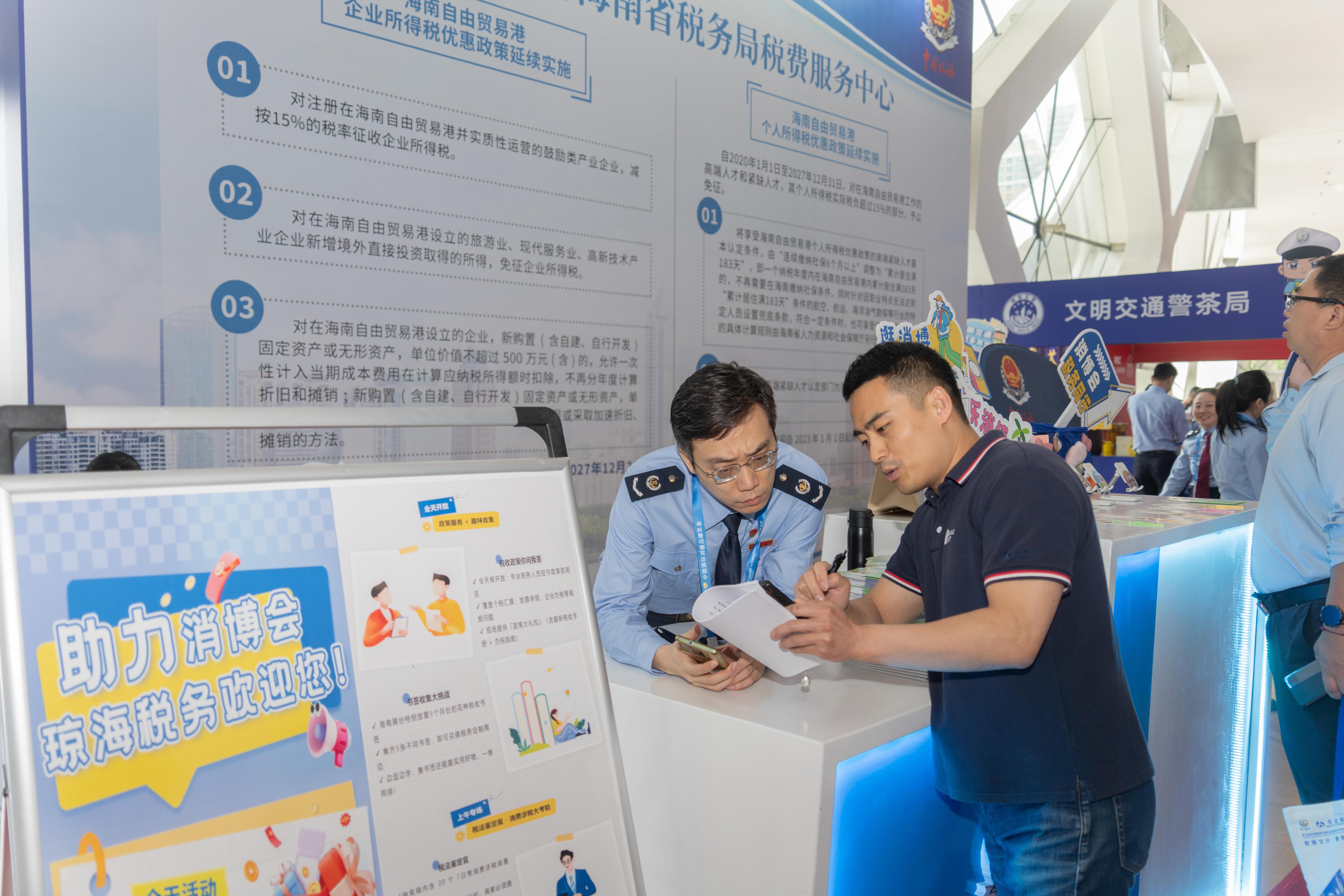 稅務服務臺工作人員向記者介紹服務參展外商的具體舉措,。人民網(wǎng)記者 許崢攝