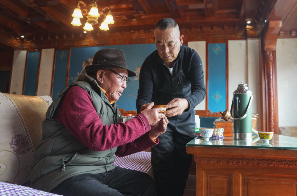 洛桑老人的孩子给老人敬茶（3月20日摄）。