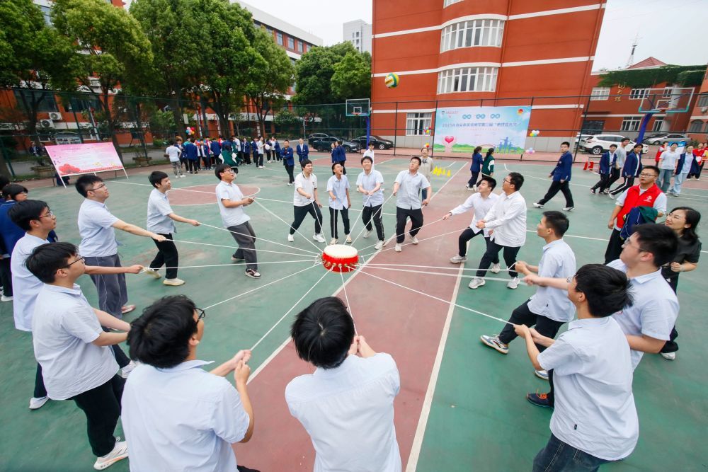2025年5月22日，江苏省海安市实验中学高三学生在体验“同心击鼓”游戏。高考临近，各地学校组织高三学生开展不同形式的减压活动，帮助学生放松心情，迎接高考。新华社发（顾彬斌 摄）