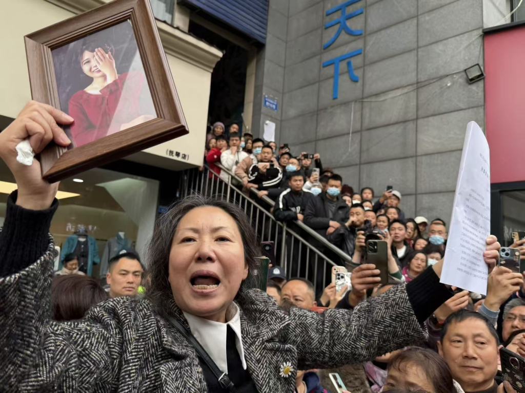 一审判决之后,受害人王某雅的母亲拿着判决书和女儿的照片离开法院。澎湃新闻记者 胥辉 摄