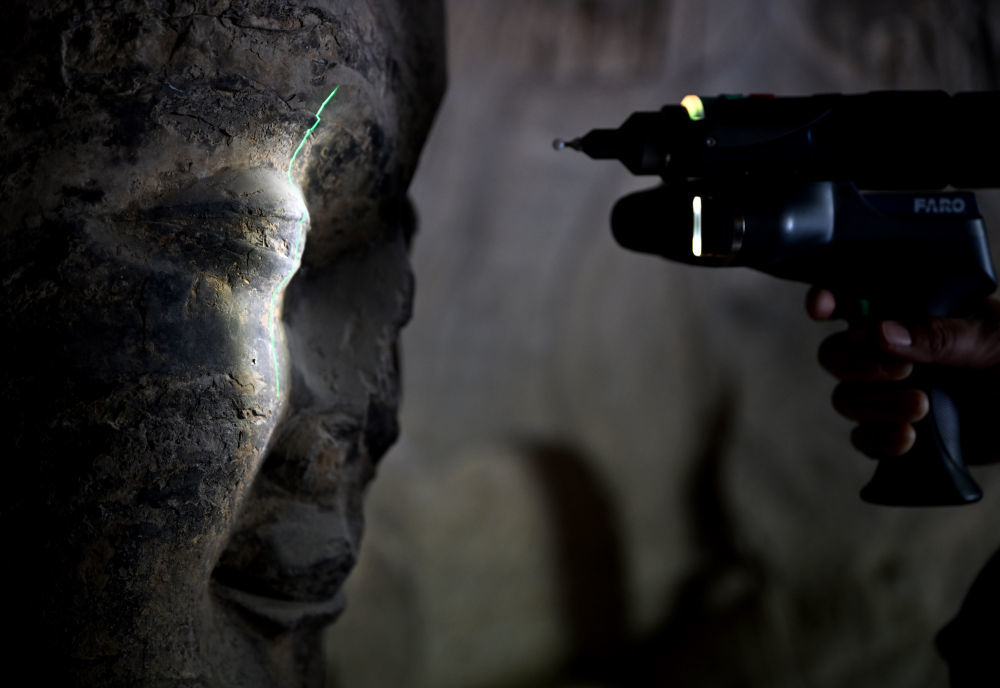 4月9日，龙门石窟研究院工作人员在魏字洞使用关节臂扫描仪对佛像进行数字化扫描。