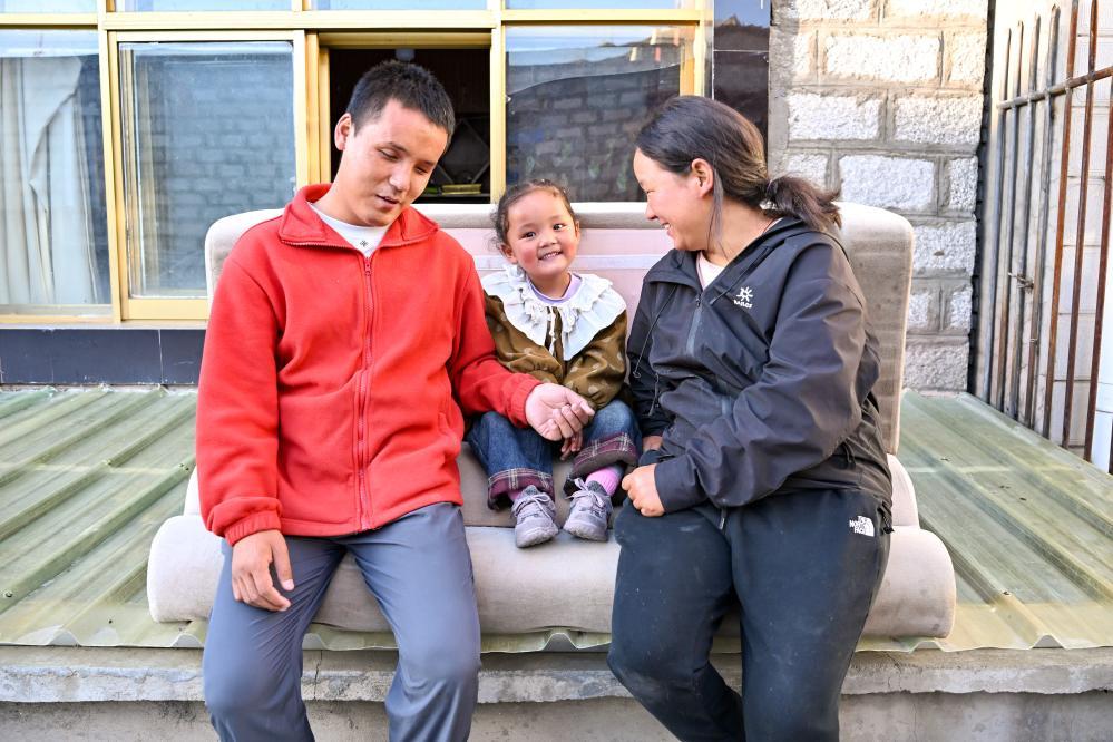 2025年10月10日，达瓦次仁和大女儿丹增曲音、妻子朋琼在露台上聊天。