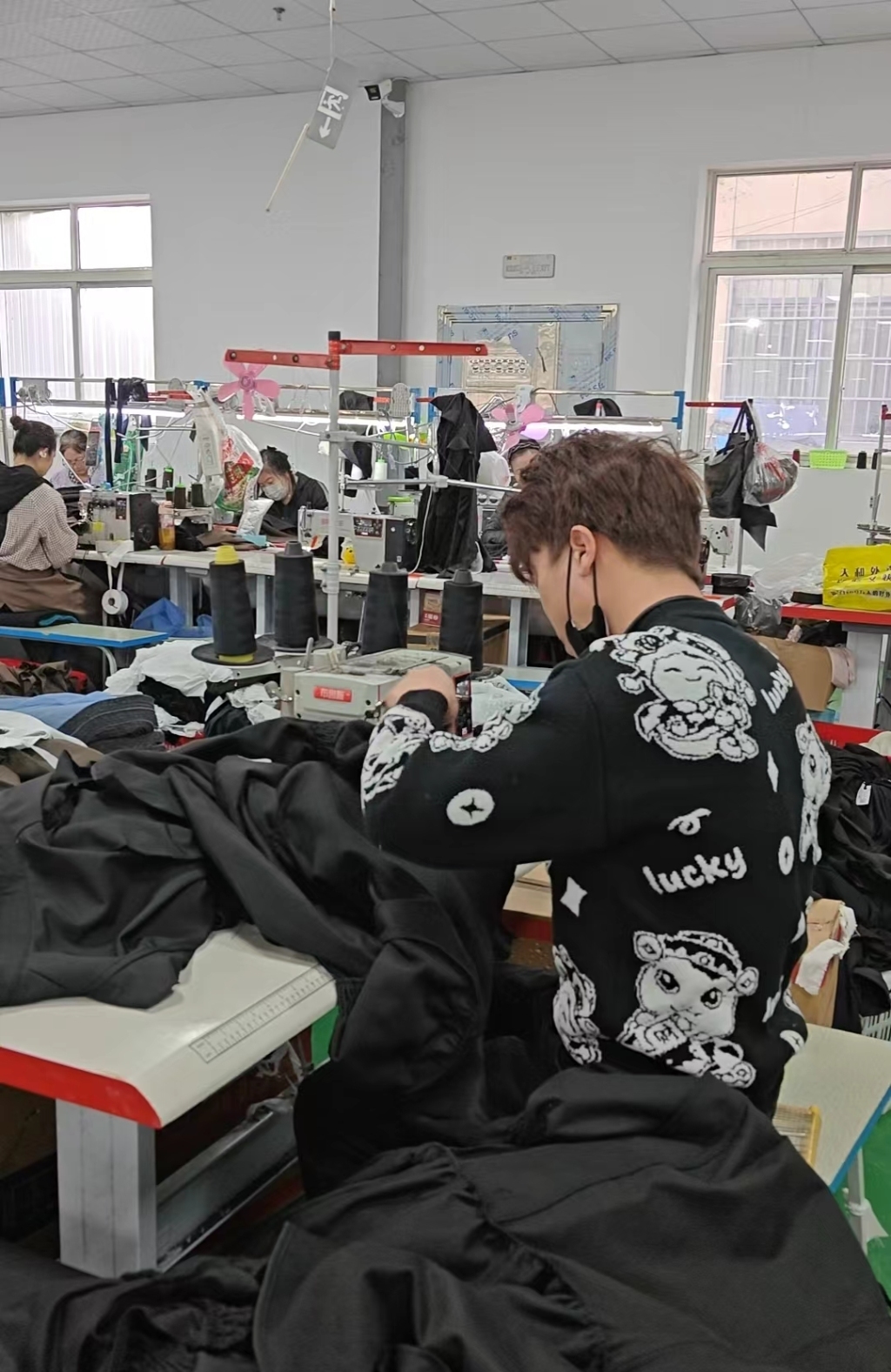 沈涛的服饰厂内,郑引和工人们正在工作。