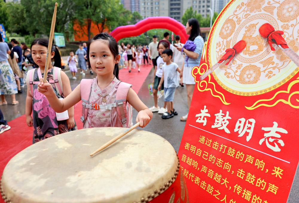 8月30日,在山东省枣庄市市中区东湖小学,一名一年级新生在“击鼓明志”。新华社发(孙中喆 摄)
