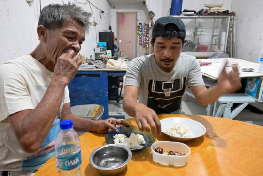 雅加达一处小吃摊,狗肉爱好者正在食用菜肴。