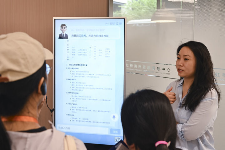 2025年9月10日，上海虹桥海外发展服务中心的工作人员（右）在展示出海服务AI工具。新华社记者 陈浩明 摄