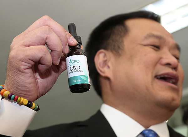 阿努廷在新闻发布会上展示一瓶提取的大麻油