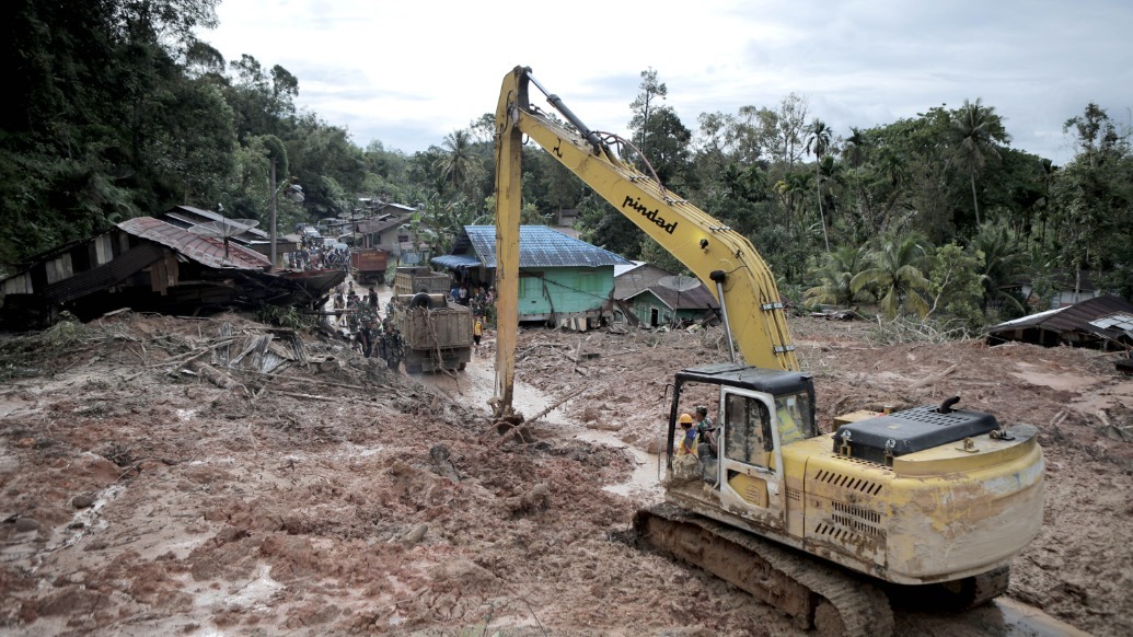 11月28日,在印度尼西亚北苏门答腊省,救援人员清理淤泥。 新华社 图
