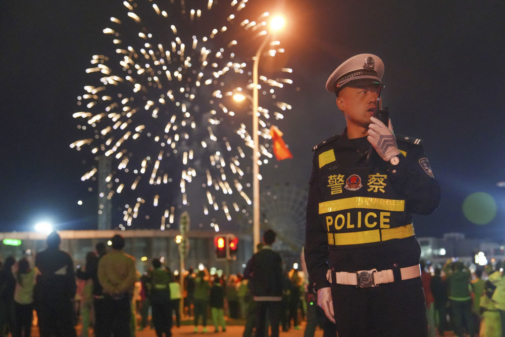 10月2日凌晨,新疆乌鲁木齐市公安局交警支队民警在乌鲁木齐市文化中心举行的“家国共此时·光焰耀天山”大型焰火燃放活动现场值守。新华社发(亚力昆江·亚森 摄)
