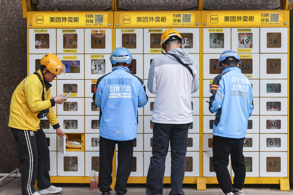 　　2025年4月22日，江苏省南京市，外卖员在智能外卖柜前投放餐品。新华社发（史俊摄）
