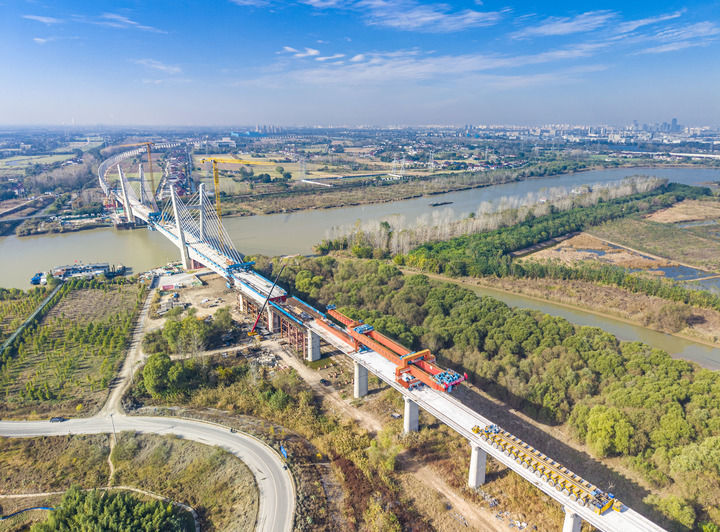 2025&#2418011&#2637620日，中铁建大桥局施工机械在沪渝蓉高铁江都段最后一榀箱梁架设现场作业（无人机照片）。新华社发（任飞摄）