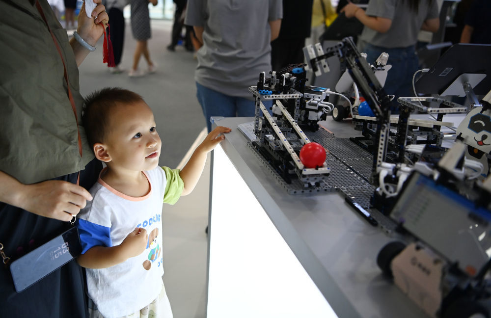 ↑ 9月11日，在服贸会教育服务专题展区，一名小朋友在猿编程展台观看最新AI教育产品。