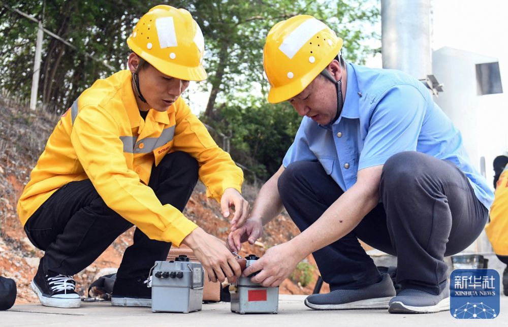 彭春林(右)在国铁南宁局职工培训基地指导青年职工使用电极型接地仪测试卡(4月25日摄)。