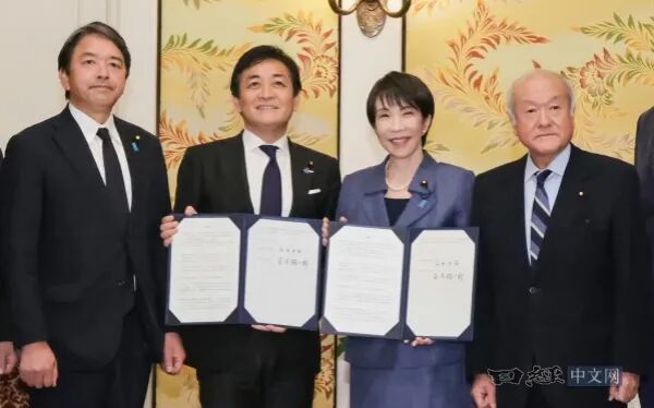 12月18日，高市早苗与国民民主党代表玉木等人达成将“年收入壁垒”提高至178万日元的协议后在国会内手持文件拍照。