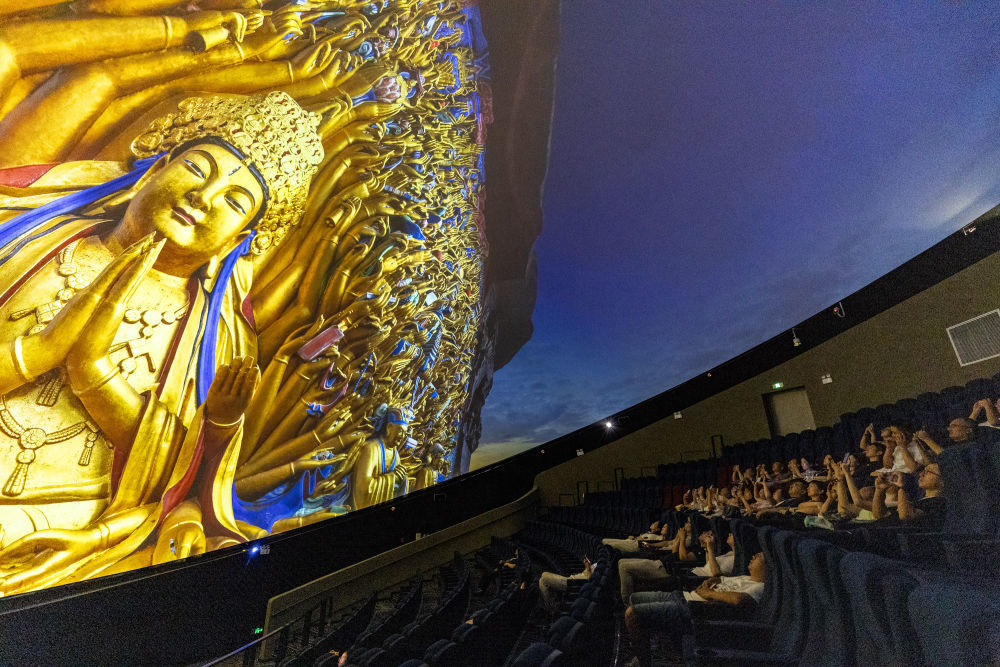 2024年9月27日，游客在重庆大足石刻景区观看8K数字球幕影片《大足石刻》。新华社记者 黄伟 摄