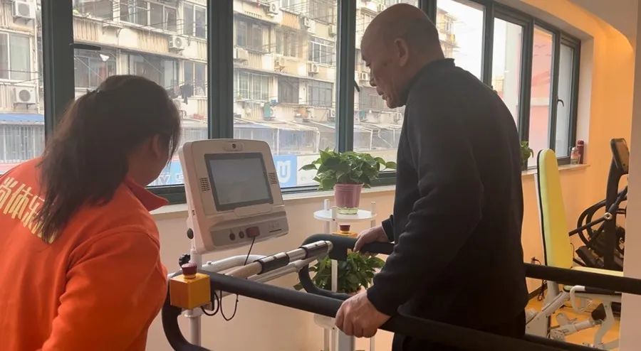 长者健身房的工作人员在帮助老人操作健身器材。杨书源 摄
