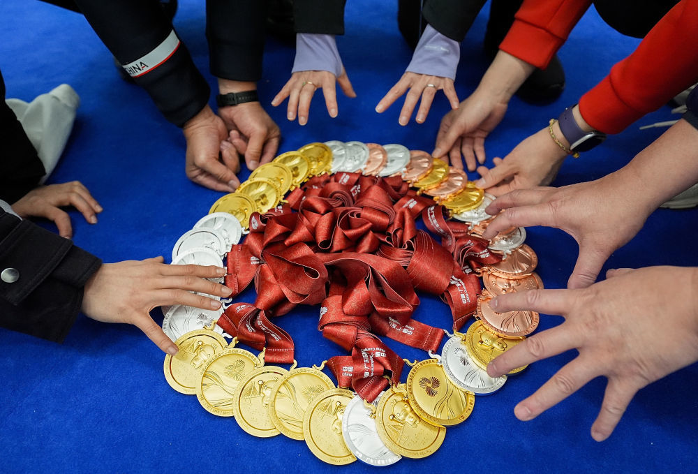 12月14日，上海轮椅击剑队队员、领队和教练在展示上海队获得的轮椅击剑奖牌。新华社记者 侯俊 摄