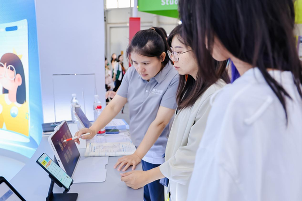 展区工作人员为参展观众讲解小猿AI学习机T4的各项功能