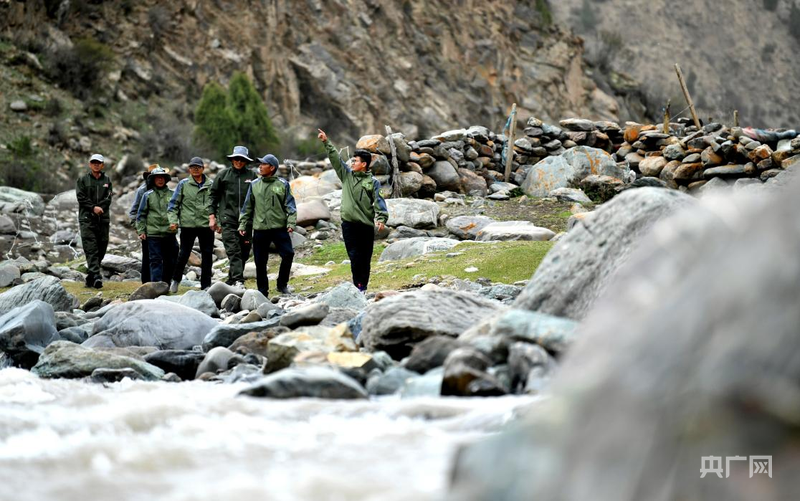 哈雪兵（右一）与生态管护员在巡山途中（央广网记者 贾海元 摄）