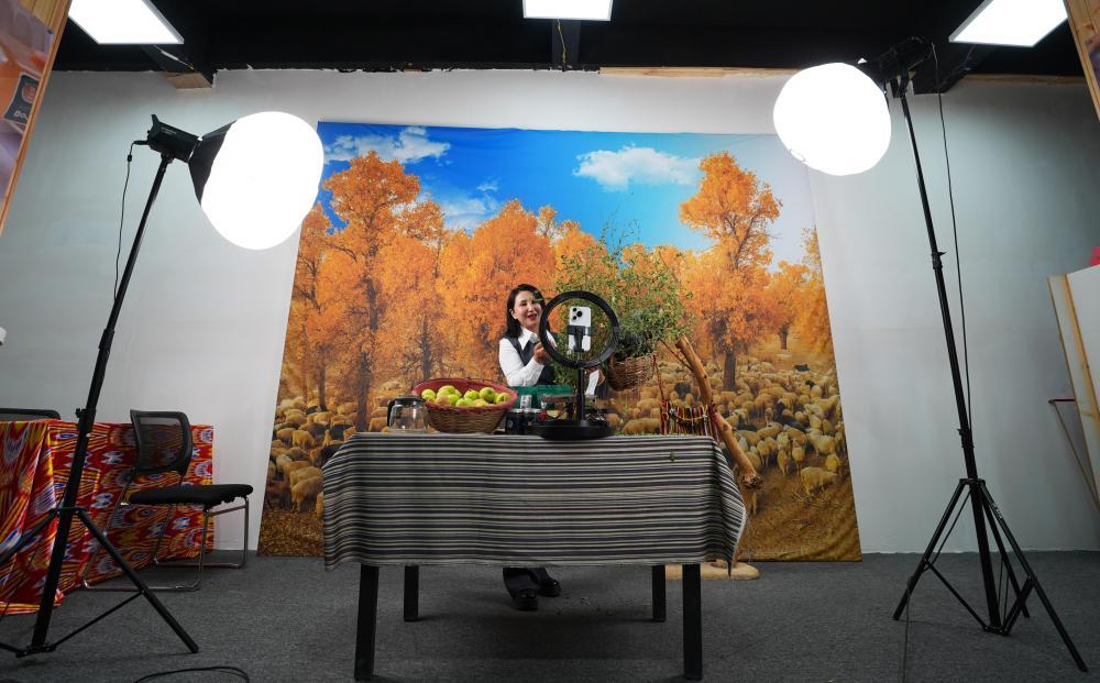 9月19日,尉犁县电商协会负责人米日阿依·阿西木在达西村的电商基地直播推介达西村农产品。近年来,达西村构建“农户生产+企业加工包装+电商销售+物流配送”全产业链,为县域经济发展培养孵化本土直播电商人才,促进传统产业转型升级。