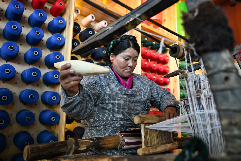 2024年9月3日，在西藏日喀则市江孜县班觉伦布村的阿佳格桑工坊，一名藏族村民使用传统织机编织氆氇。氆氇是藏族群众用来制作藏式衣物的毛织品，其工艺迄今已有上千年历史。在上海援藏帮扶下，这项传统技艺如今已成为当地妇女的致富新途径。新华社记者 孙瑞博 摄