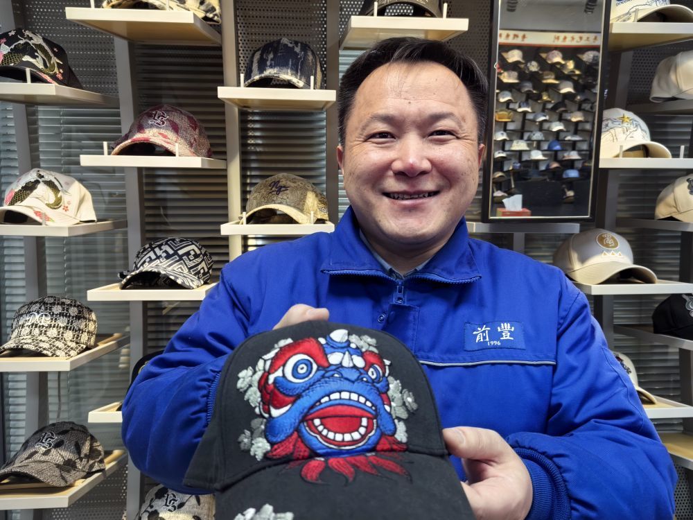 前丰帽艺副总经理杨国柱展示自主品牌运动帽产品。新华社记者 王欢 摄