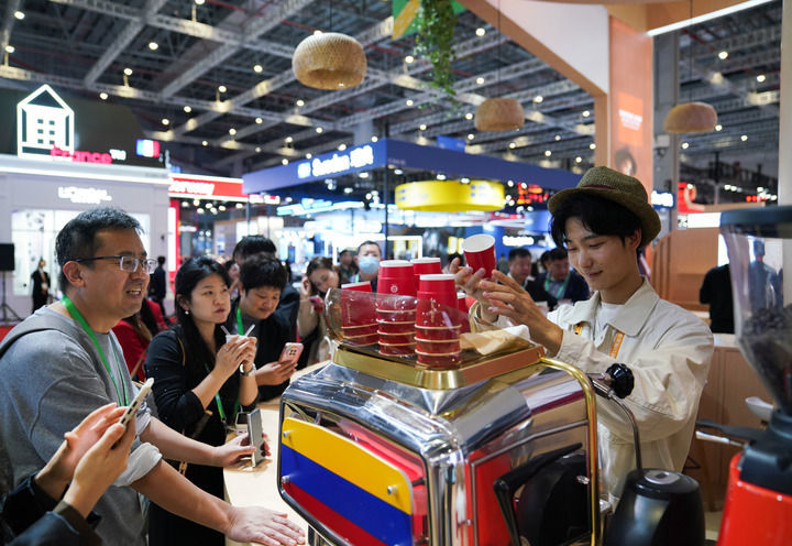 2025年11月5日,人们在第八届进博会国家展哥伦比亚馆排队品尝咖啡。新华社记者 樊雨晴 摄