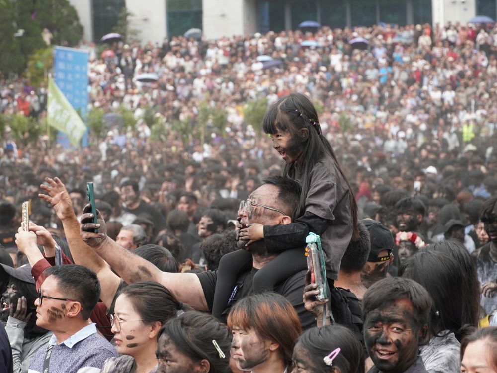 5月2日，游客和当地群众在云南省墨江哈尼族自治县参加“抹黑脸”民俗活动。（墨江县融媒体中心供图）