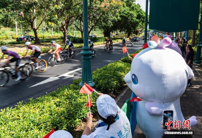 11月8日，第十五届全国运动会(十五运会)公路自行车男子个人赛举行，这是本届全运会唯一一项跨越粤港澳三地的比赛项目。图为在位于香港迪士尼乐园度假区幻想道的赛道旁，市民、志愿者、吉祥物“喜洋洋”“乐融融”等为选手加油助威。　中新社记者 侯宇 摄