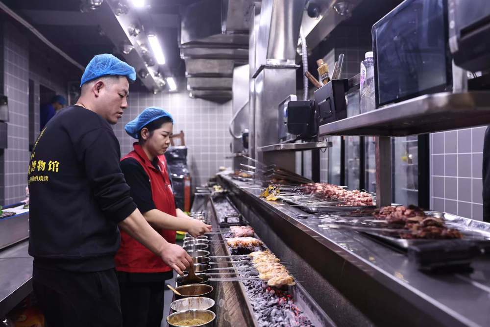 4月14日,锦州市“御烧烤”烧烤店厨师为食客烤制食材。新华社记者潘昱龙 摄