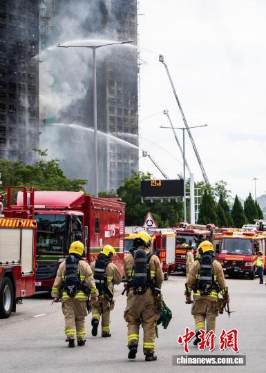 图为增援轮替的消防员前往火灾现场。　中新社记者 侯宇 摄