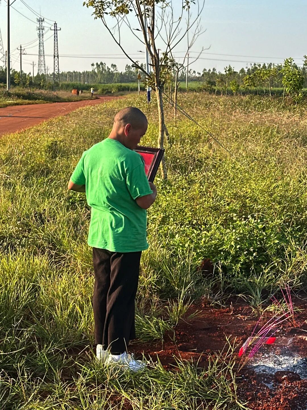 李海玉带着父亲遗像重返当年弟弟的埋尸处祭拜