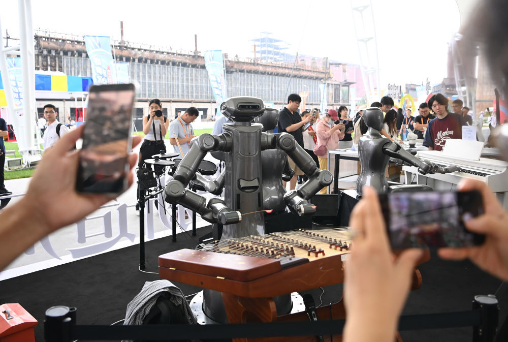 ↑ 9月11日，在服贸会户外展区，参观者拍摄演奏乐器的机器人。