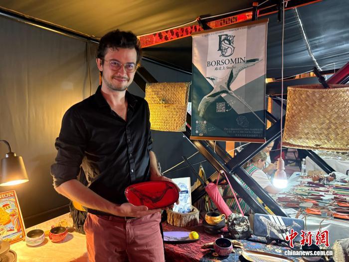 10月17日晚，一位来自法国的艺术家正在陶溪川春秋大集上展示他的作品。中新社记者 李韵涵 摄