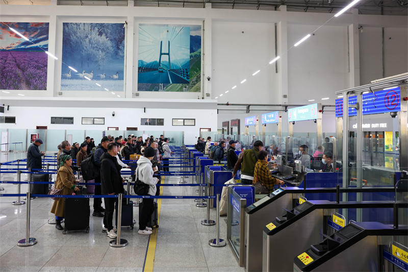 图为霍尔果斯公路口岸旅检现场出境旅客有序排队等待办理出境边检手续。曹荣摄