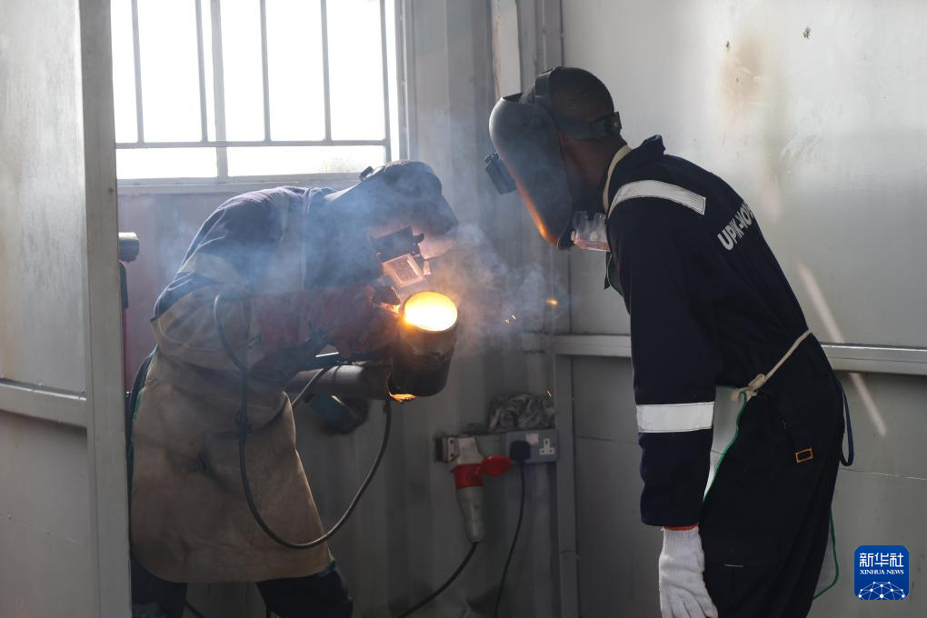 6月16日,在乌干达基贡巴石油学院,两名学员在焊接工位进行练习。新华社发(中石化供图)