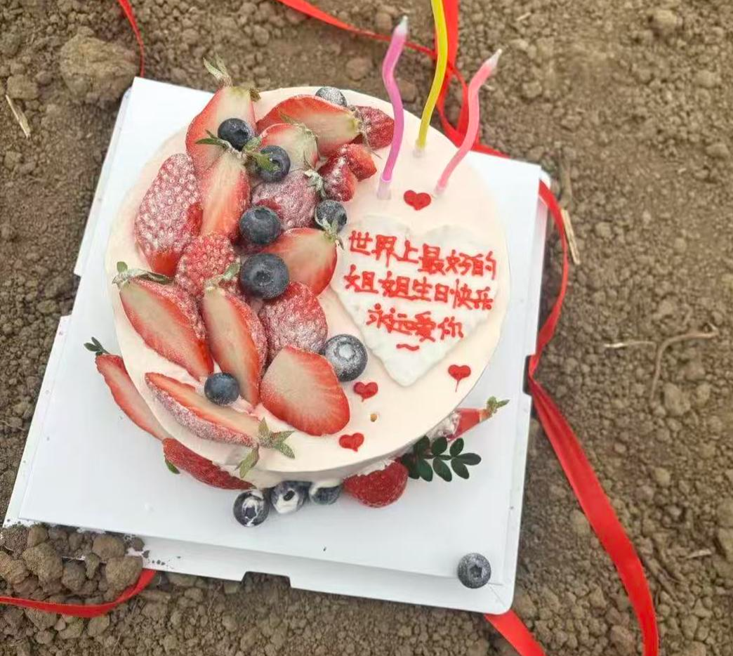 ▲22日,家里人买好蛋糕来到坟前,提前给小霞