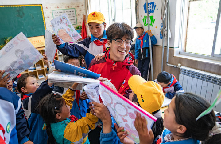 在西藏林芝市工布江达县娘蒲乡中心小学，孩子们把自己做好的手抄报展示给岭南师范学院支教队队员胡正培（2024年9月3日摄）。新华社记者 丁增尼达 摄