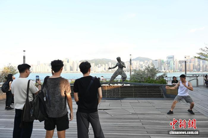 10月8日是2025年中国内地国庆中秋8天长假最后一天。当天,不少游客在香港多地游玩,度过假期。图为游客游览位于尖沙咀的李小龙铜像。 中新社记者 李志华 摄