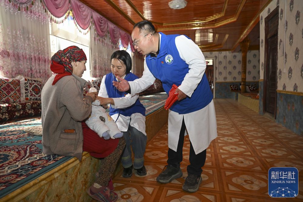 ↑ 在新疆塔什库尔干塔吉克自治县库科西鲁格乡瓦窑本村，深圳援疆新生儿科医生潘千（中）与同事许林森（右）在村民家为新生儿检查身体，并叮嘱养护注意事项（2025年3月24日摄）。新华社记者 胡虎虎 摄